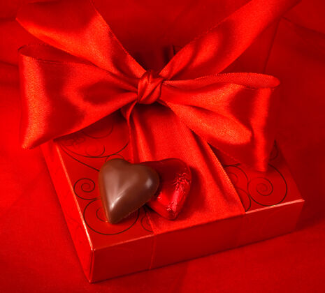周年纪念情人节天礼物红色背景上的心形盒子和糖果优雅盒子松露