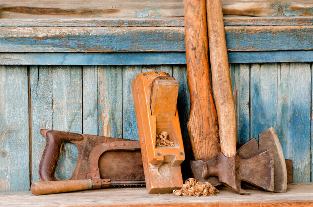工匠斧子 刨花 看到了老蓝色木背景锯斧头古董