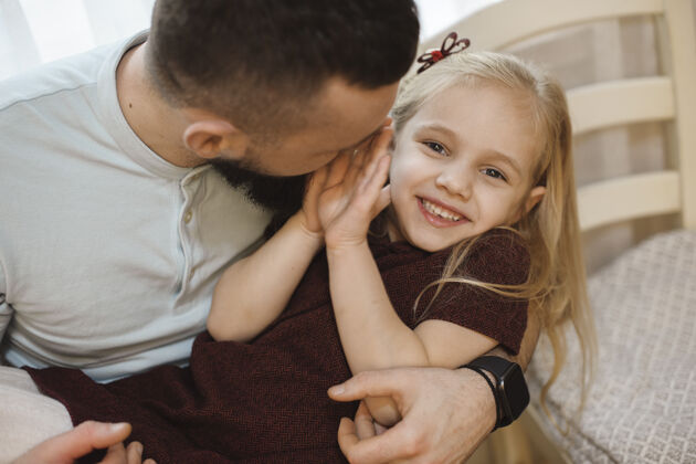 金发他父亲抱着一个快乐的小女孩笑的画像武器父亲妈妈工作的时候 女儿在家玩玩耍小父母