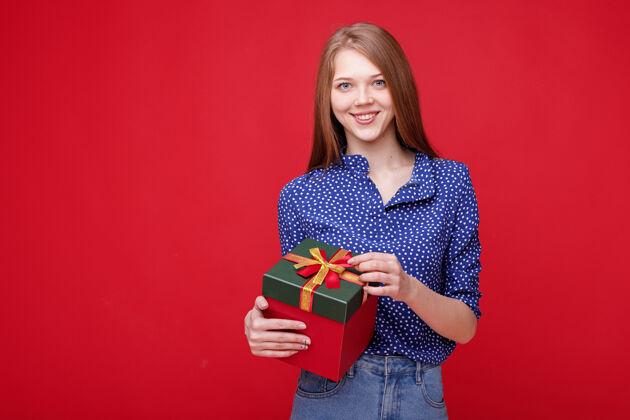 盒子那女孩微笑着 手里拿着一件红色的礼物背景.国际妇女节给予手势国际