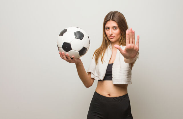 拒绝年轻的健身俄罗斯女子举手前部保持架一个足球停止女人墙