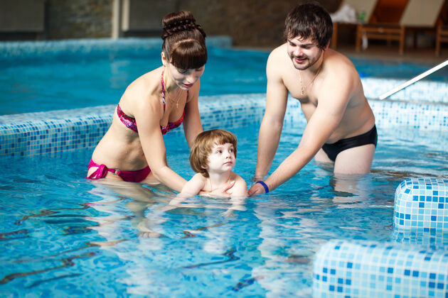 父母一家人在游泳池里游泳儿子自信游泳
