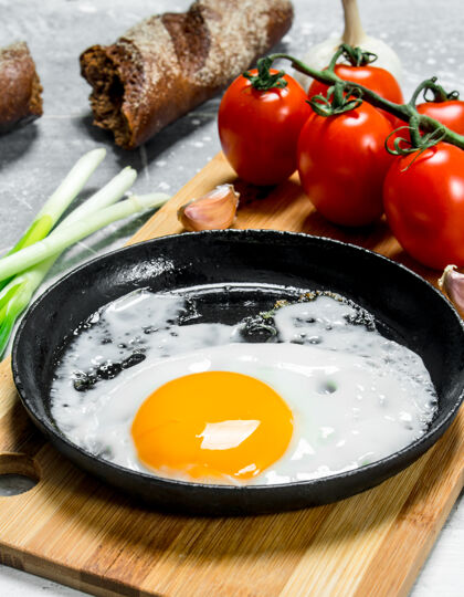 特写在平底锅里煎鸡蛋 加西红柿和葱胡椒新鲜食物