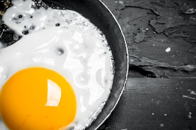 食物在煎锅里煎鸡蛋健康早餐胡椒