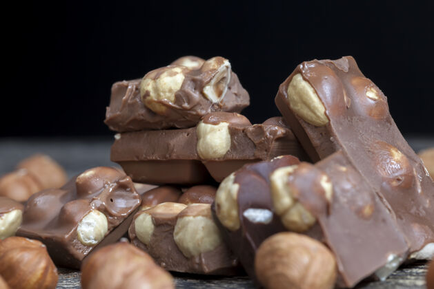 糖果特写榛子和巧克力混合在甜巧克力制成的可可和可可脂与坚果巧克力美味黑巧克力