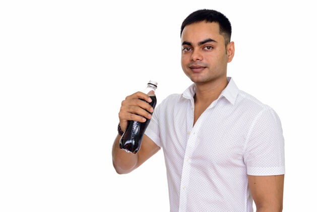 刷新年轻英俊的印度男子喝着苏打水隔离在白色的空间饮料持有苏打水