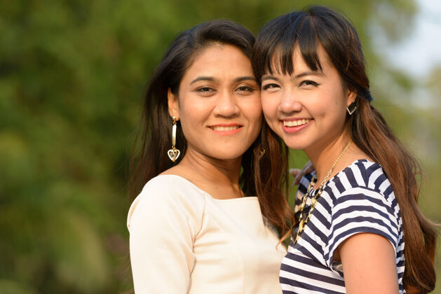 自然两位亚洲年轻女性在公园户外放松的写真情侣公园关系