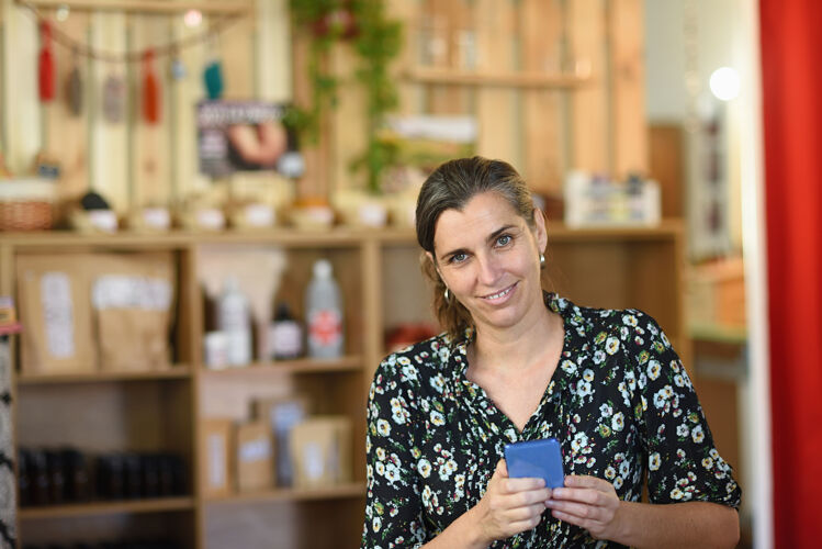 商店一个有进取心的女人拿着手机在商店里的画像企业家电话肖像