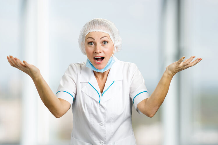 帽子快乐的女医生举手示意快乐的成熟护士或医生看起来很惊讶护士医学女人