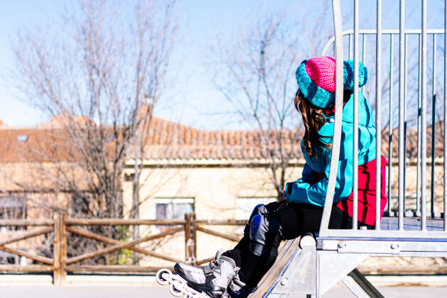 骑手坐在溜冰场上的金发溜冰女的画像匝道.市区滑冰概念休闲滚轴溜冰鞋极限