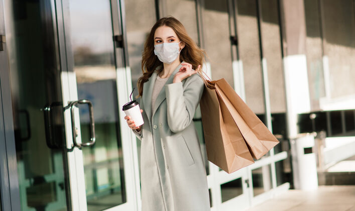 病毒在欧洲狭窄的街道上 年轻女性戴着防毒面具 带着购物袋讲话城镇药品