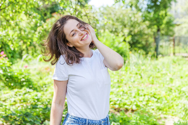 欢呼快乐的女孩在户外微笑美丽的棕发年轻女子 在公园或花园的绿色背景下休息表情自由女性