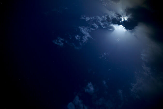 黑暗夜空中云后的月亮占星术夜晚辉光