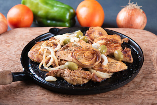 乡村风味铁板上放着洋葱和橄榄的烤鸡家禽晚餐餐