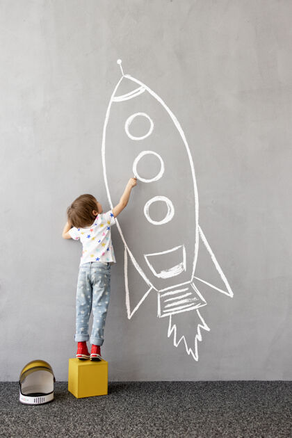 梦想梦想大快乐的孩子在墙上画一个粉笔火箭幼儿自由孩子