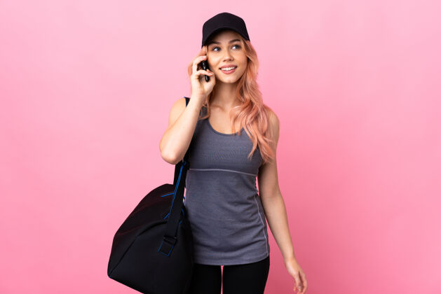 运动员带着运动包的运动女人用手机聊天通信女性护理