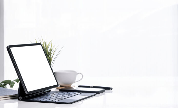 咖啡模拟白屏平板电脑与魔术键盘上的白色桌子白色明亮的背景和复制空间桌子房子产品