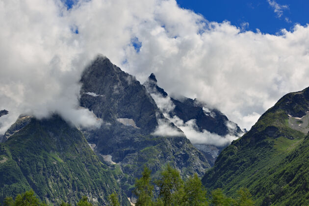 美丽山顶上有冰川映衬着云层和天空的表面高山山脉自然