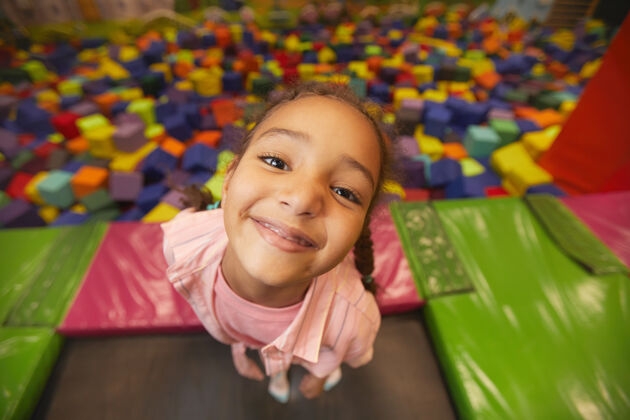 蹦床在蹦床中心玩耍的小女孩微笑的画像抱着快乐兴奋