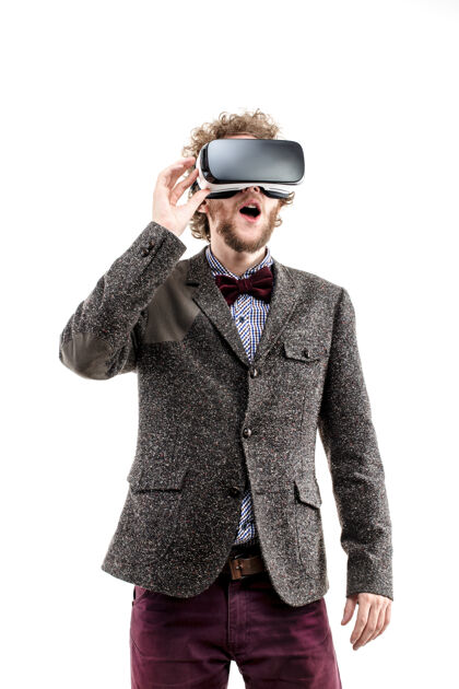 享受年轻的卷发商人穿着棕色西装使用虚拟现实耳机和体验虚拟现实隔离小玩意虚拟年轻
