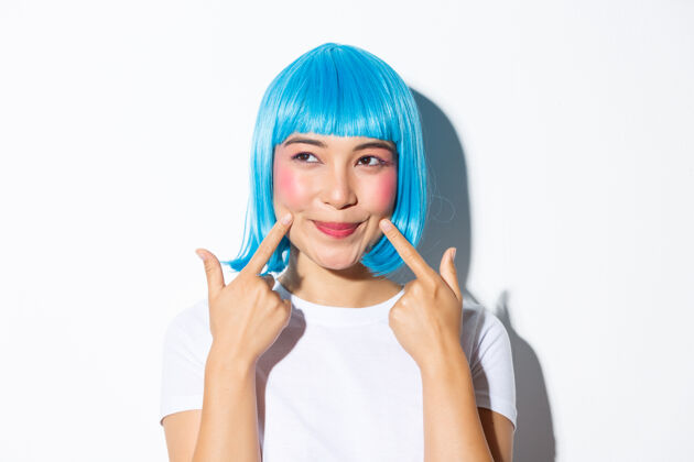 年轻戴蓝色假发的亚洲女孩摆姿势假发表情表情