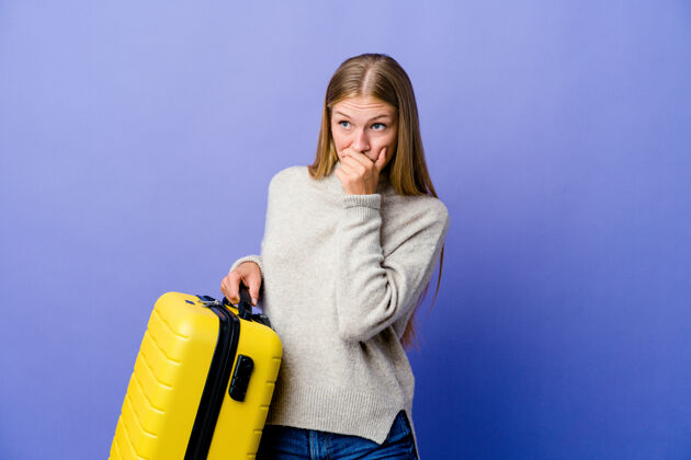 思考年轻的俄罗斯女子拿着手提箱旅行 若有所思地看着一个用手捂住嘴的复印空间嘴护照包