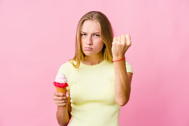 武力一个年轻的俄罗斯女人在吃冰淇淋时 对着镜头露出拳头 咄咄逼人的表情食物愤怒暴力