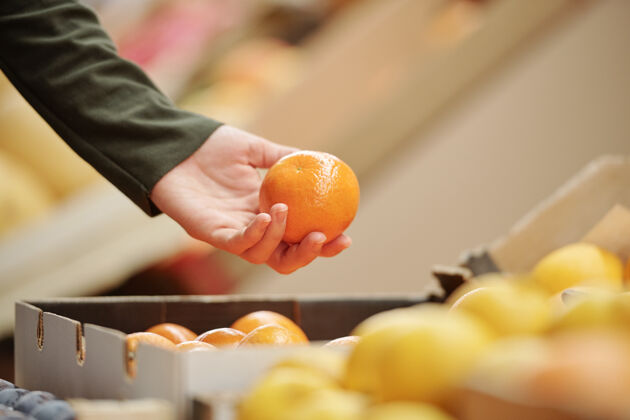 杂货店在有机食品市场选购橘子的不知名人士特写 购物理念蔬菜食物人手