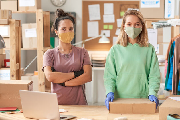 包装两个戴着口罩的妇女的画像 在前面的送货处工作办公室休闲服