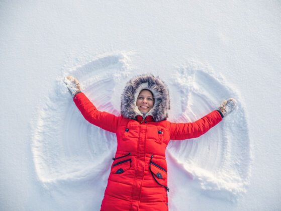寒冷雪天使由一个快乐的女人做的雪地.top平面俯视图欢乐放松天使