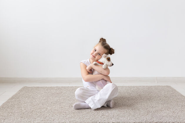 表情人们儿童和宠物概念小女孩坐在地板上与可爱的小狗杰克罗素肖像狗狗