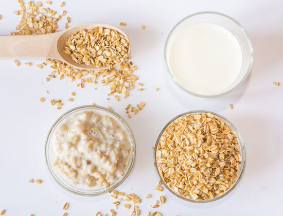 谷类一杯牛奶 燕麦片和粥放在盘子里 放在白色的表面上从上面看燕麦健康种子