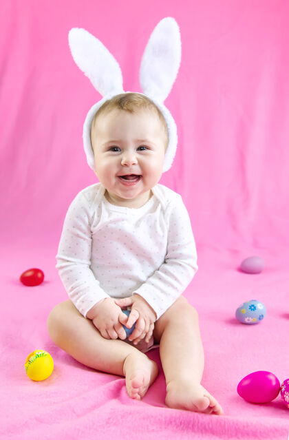 快乐穿得像兔子的宝宝 带着复活节彩蛋过复活节兔子有趣抱着