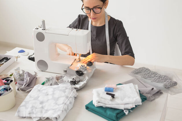 黑发人 裁缝 时尚理念——工作场所服装设计师用缝纫机的特写写真纺织品时装女裁缝