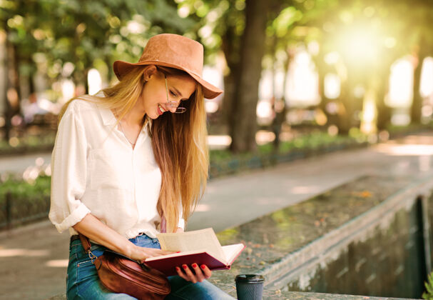 休闲年轻的女学生穿着休闲服 坐在城市的户外看书肖像教育女人