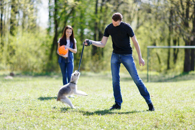 女人女孩和男孩在训练狗男性团体家庭
