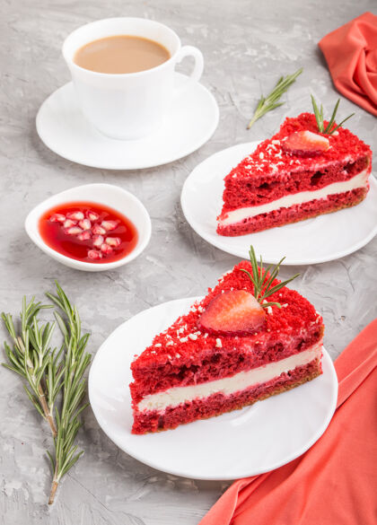 早餐自制的红色天鹅绒蛋糕和牛奶奶油和草莓咖啡杯在灰色混凝土表面与红色纺织品甜点特写草莓