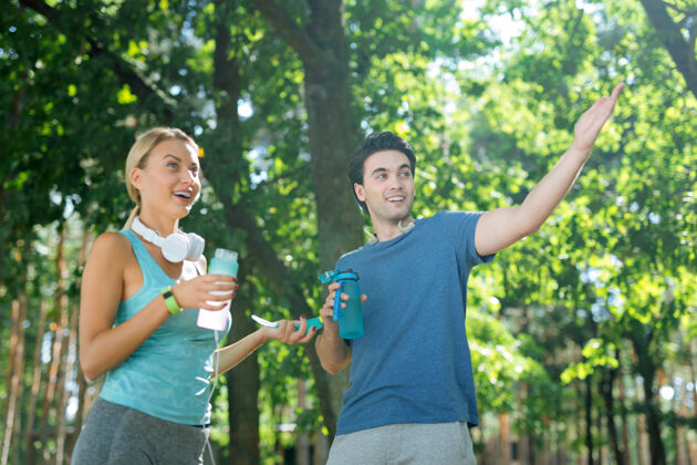 移动一杯新鲜的饮料帅哥拿着一瓶水和他女朋友说话情绪健康运动