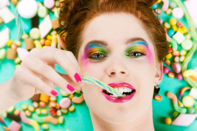 糖有许多不健康的甜食或糖果的年轻女子 她爱吃甜食颜色牙齿糖果