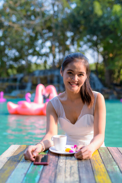 衣服年轻美丽的亚洲女游客在湖边户外放松的画像咖啡船肖像