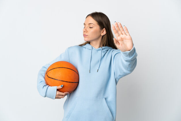 爱好年轻的立陶宛女子打篮球孤立在白色背景下作出停止的姿态和失望运动球员手势