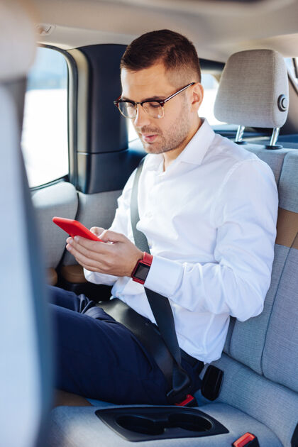 工作在线交流聪明英俊的商人坐在车里查看信息智能城市智能
