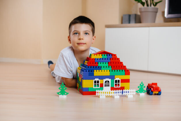 设计师一个小男孩玩着一个建筑工具 为全家建造了一座大房子建造一个家庭住宅快乐公寓建筑商