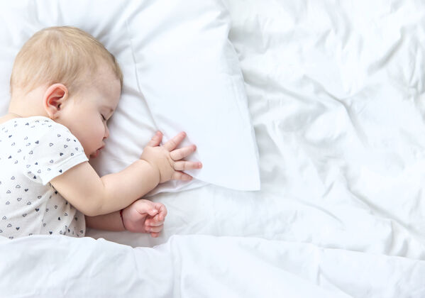 就寝时间宝宝睡在白色的床上谎言肖像小
