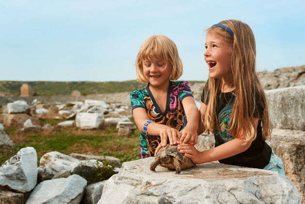 外面两个微笑的小女孩在玩乌龟孩子公园小