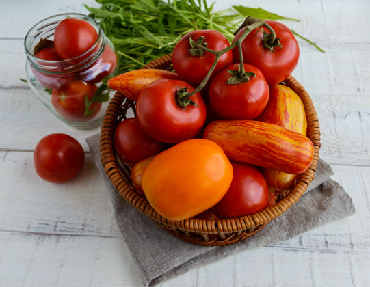 不同篮子里放着不同品种的西红柿和芝麻菜 放在白色的木头表面上颜色饮食营养