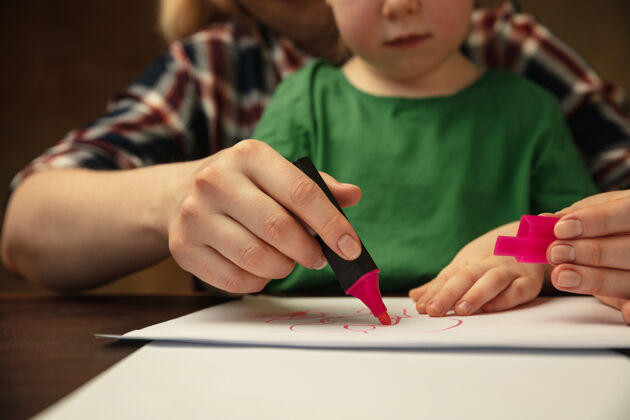 人用彩色记号笔画画女性和儿童手一起做不同事情的特写镜头家庭 家庭 教育 童年 慈善理念母亲和儿子或女儿 学习家庭关怀父母