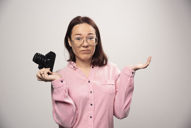女人女摄影师拿着一个白色的相机高质量的照片成人拍摄肖像
