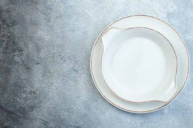 陶瓷器皿空的白色汤盘在左侧的半暗浅灰色表面与苦恼的表面与自由空间容器杯子咖啡