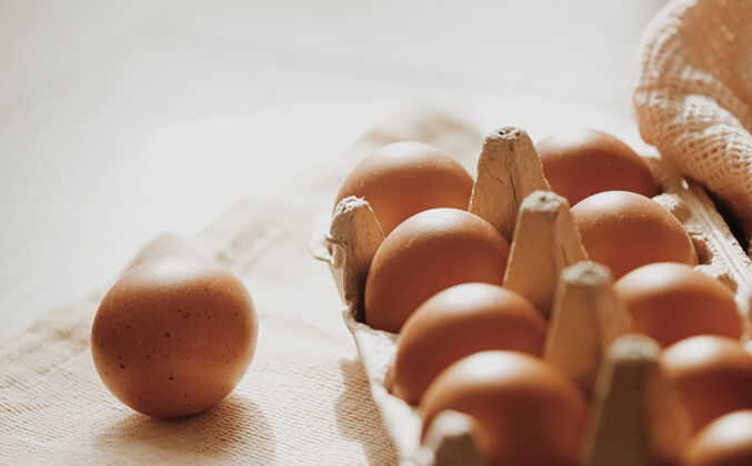 团体有机农场鸡蛋在鸡蛋盒和乡村布餐巾 特写配料食物鸡蛋